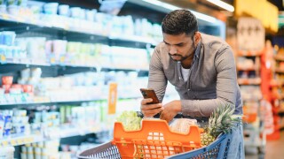 Male,Consumer,Comparing,Prices,And,Products,On,His,Phone,While