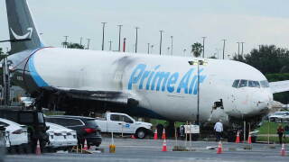 Workers inspect an Amazon cargo plane that overshot a runway four days ago at Miami International Airport, Thursday, Sept. 10, 2026, in Miami. 