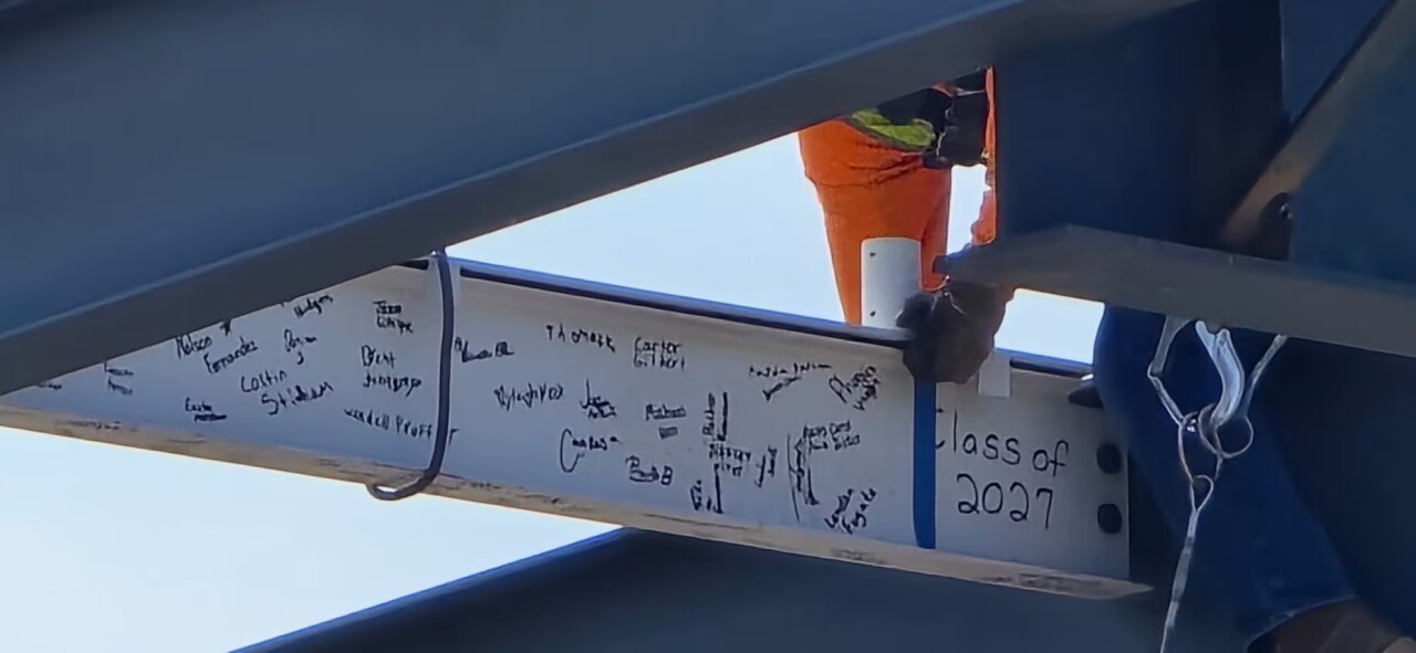 Students and officials signing the last steel girder new Aviation Center