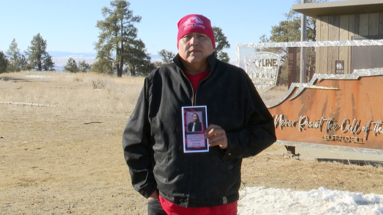 Daniel LaForge holding up his sisters memorial pamphlet