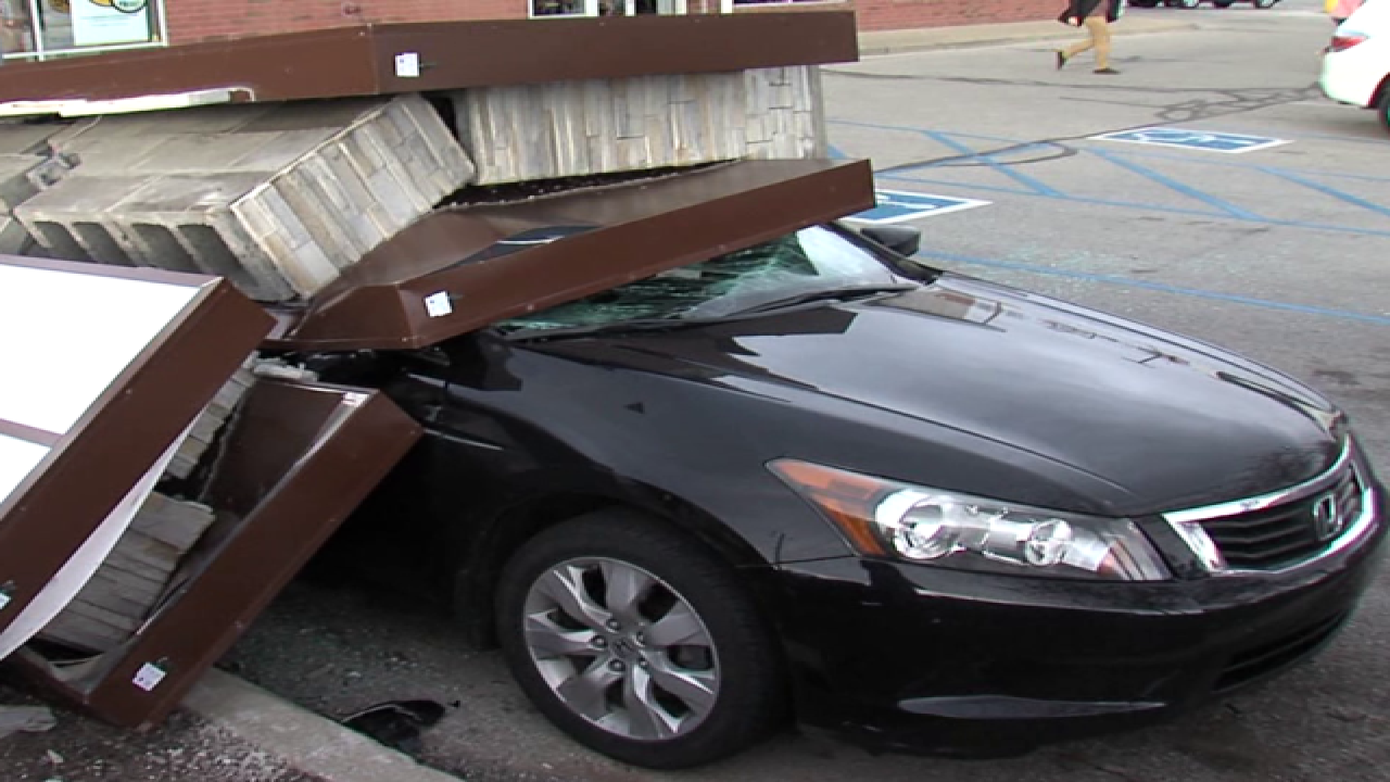 PICS: Sign falls on car, driver gets out