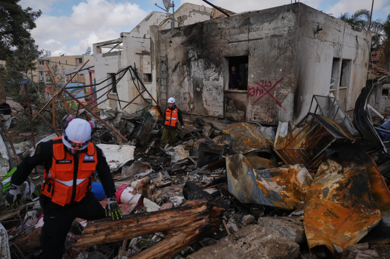 Israeli security forces survey the site that was struck by an Iranian missile in Dimona, southern Israel, Sunday, March 22, 2026.