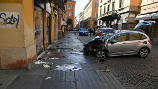 Blood is seen next to a destroyed car on a street of Modena, Italy, Saturday, May 16, 2026. 