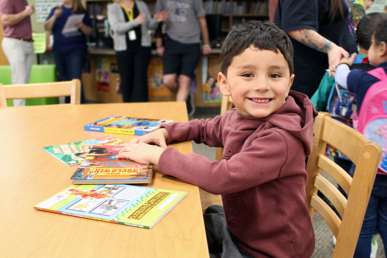 A child receives a book at a book fair. 