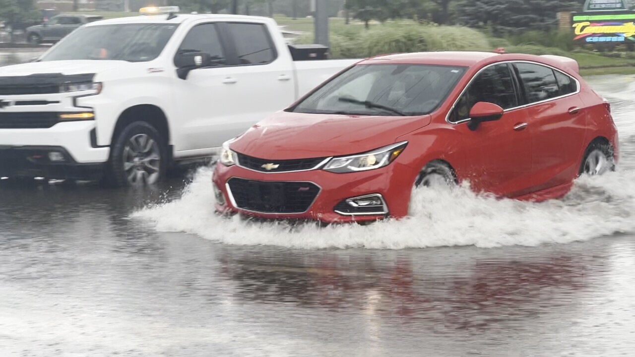 Car drivers through flooded Abbot Road while white pickup truck is stuck