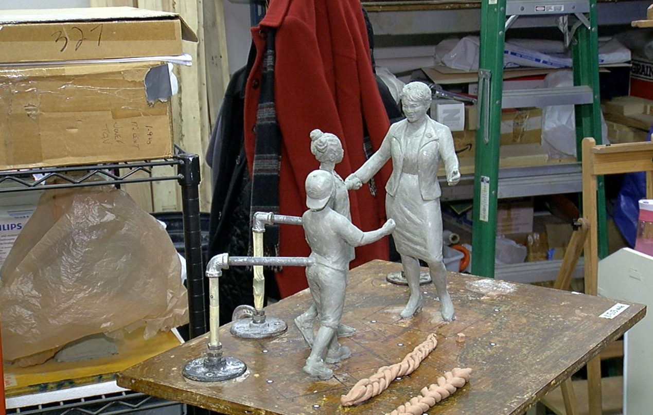 This model served as the basis for the full-size sculpture that will honor civil rights icon Marian Spencer. It shows Spencer with her arms outstretched forming a circle with a young girl and boy,