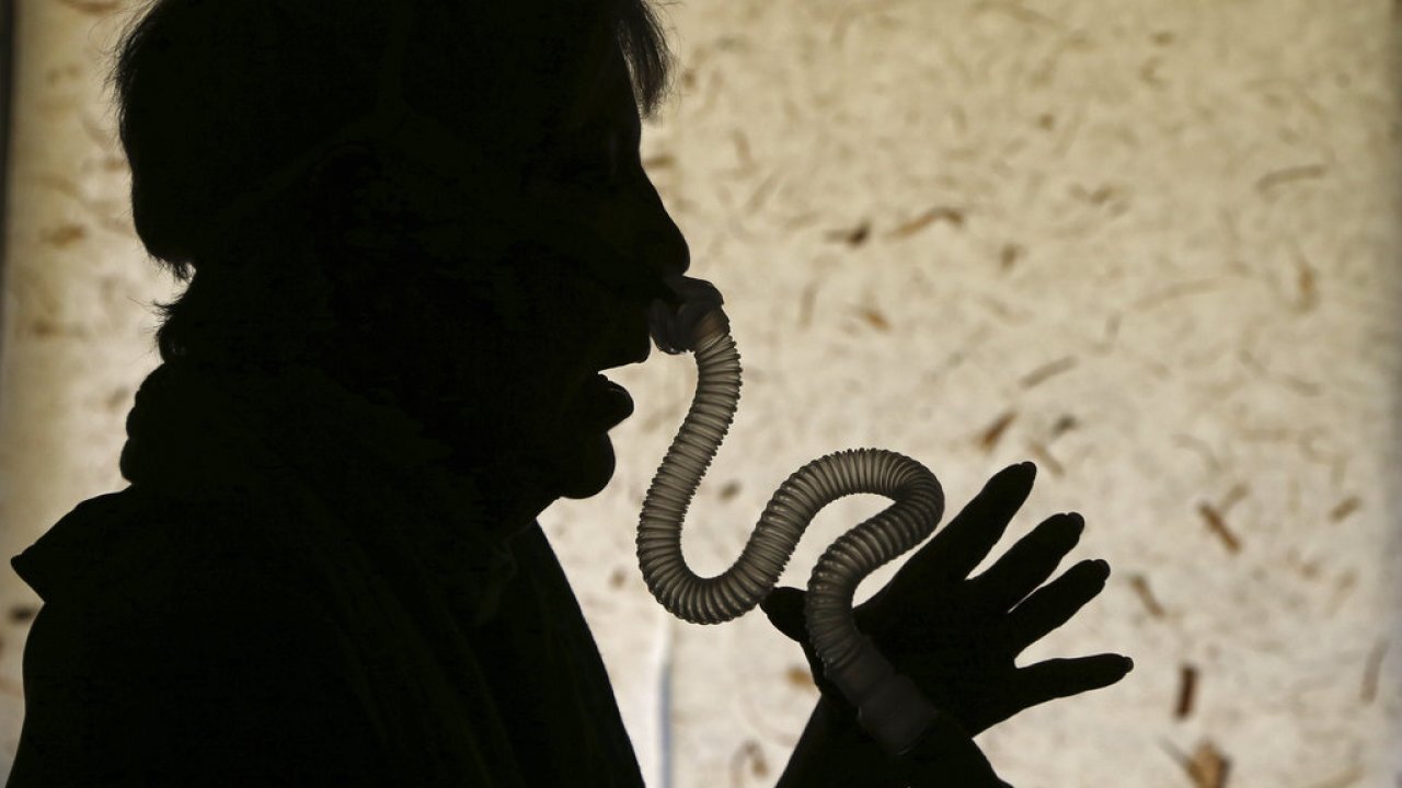 Woman puts on her sleep apnea breathing device