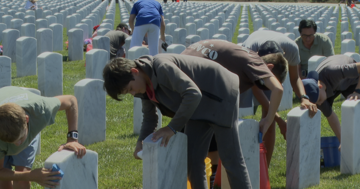 Volunteers clean tombstones at Miramar National Cemetery one day after 9/11 anniversary
