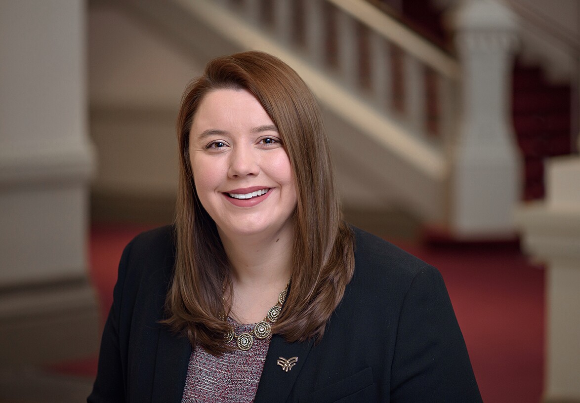 Samantha Molony is applied research director for the Women's Fund of the Greater Cincinnati Foundation. She has long, brown hair and is wearing a printed blouse and dark jacket in this photo.