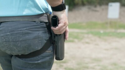 Daniel Jakobsson rests his hand on his holstered gun.