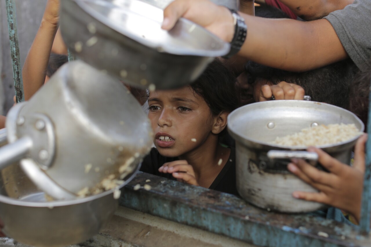 A Palestinian boy watches his portion of food aid.