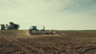 Tractor plants in field.