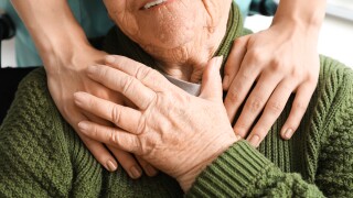 Senior,Woman,In,Wheelchair,Holding,Caregiver's,Hand,Indoors,,Closeup