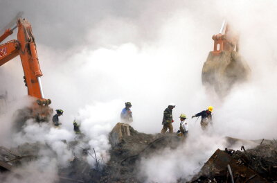  In this Oct. 11, 2001 file photo, firefighters make their way over the ruins of the World Trade Center through clouds of dust and smoke at ground zero in New York. 