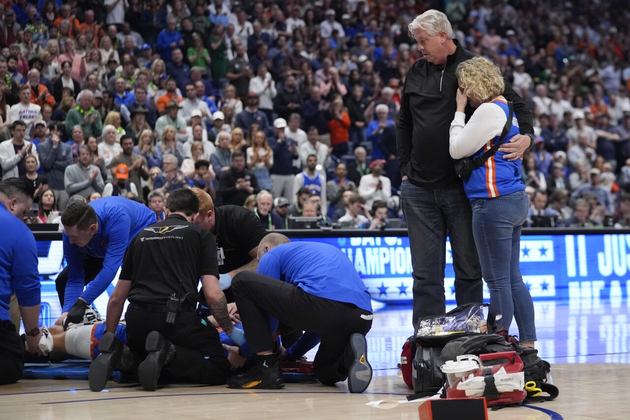 Parents of Florida Gators center Micah Handlogten stand on court after injury during first half of SEC Tournament final, March 17, 2024