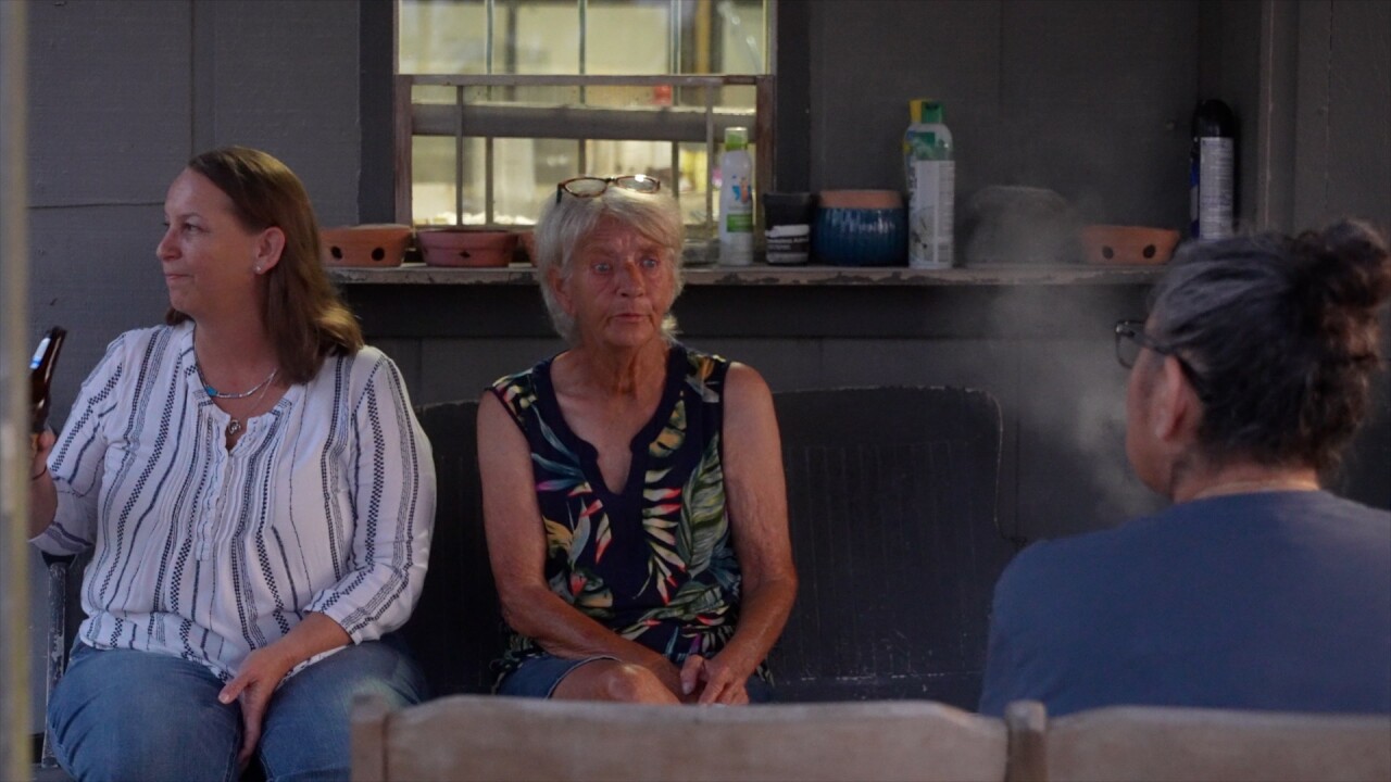 Debbie Malcomb sits on the porch of 