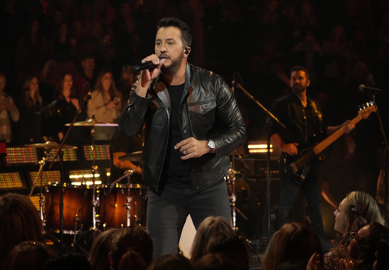 Luke Bryan holds microphone close to mouth during CMA Awards, Nov. 8, 2023