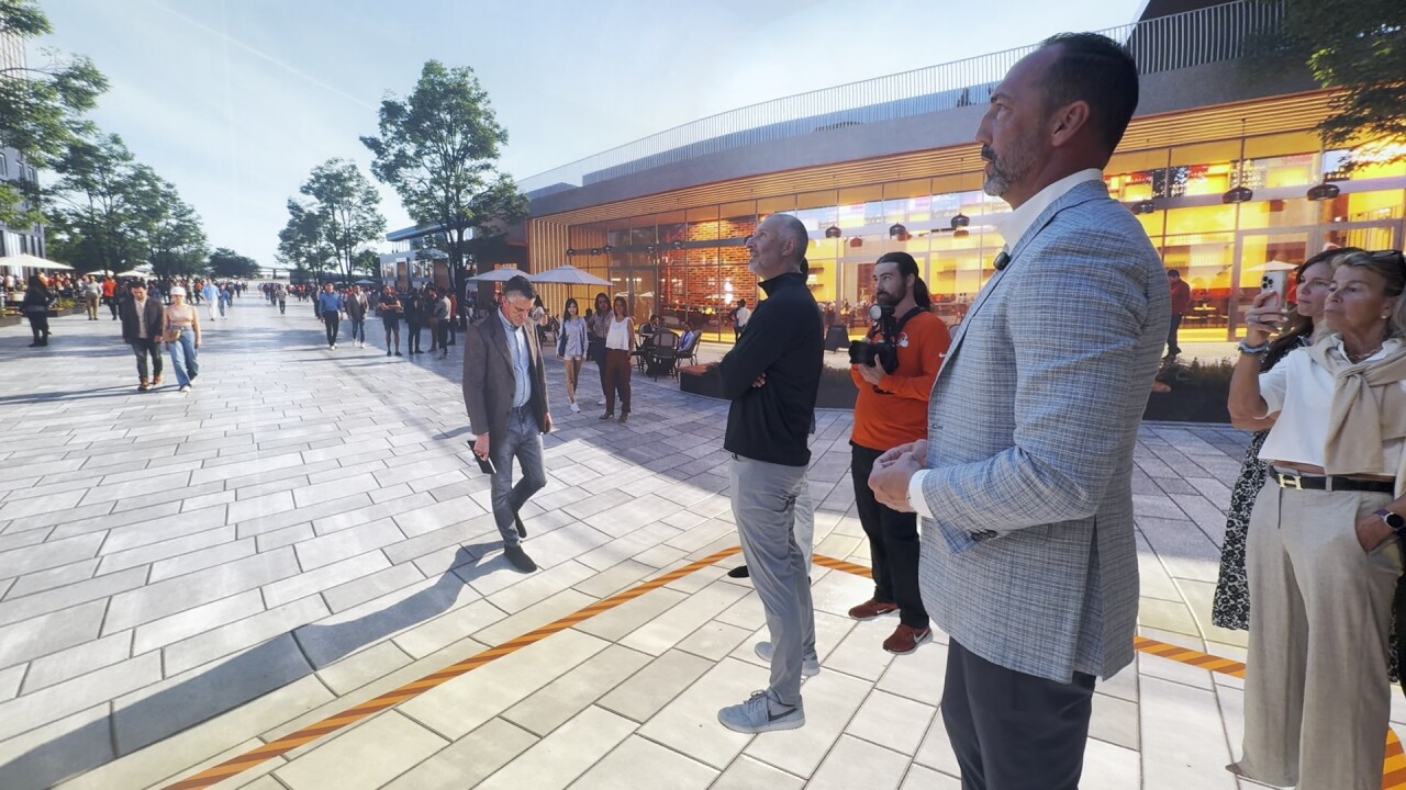 Haslam Sports Group executives and members of the Browns organization stand inside a virtual copy of the future stadium district inside their new sales center.