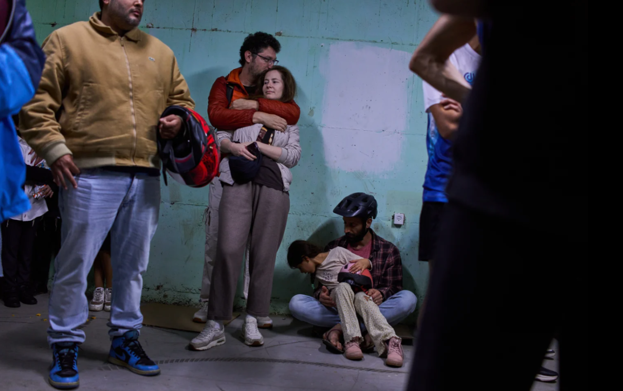 People take shelter as air raid sirens warning of incoming Iranian missiles in Tel Aviv, Israel, Saturday, March 7, 2026.