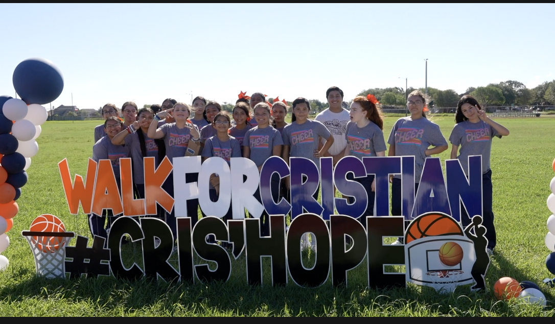 Students taking a photo with the 'Walk For Cristian' signage