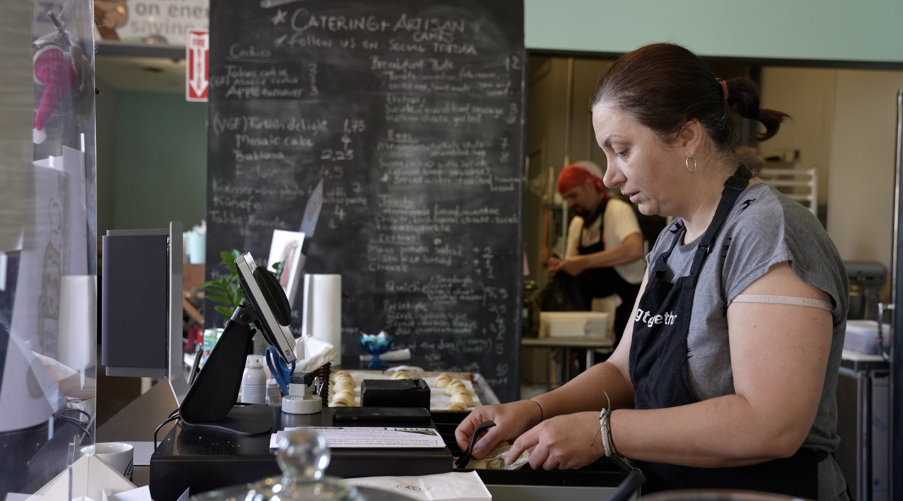 Burcay Gunguler the co-owner of the Social Sloth Cafe & Bakery is at the cash register.