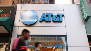 Pedestrians walk past an AT&T Wireless store