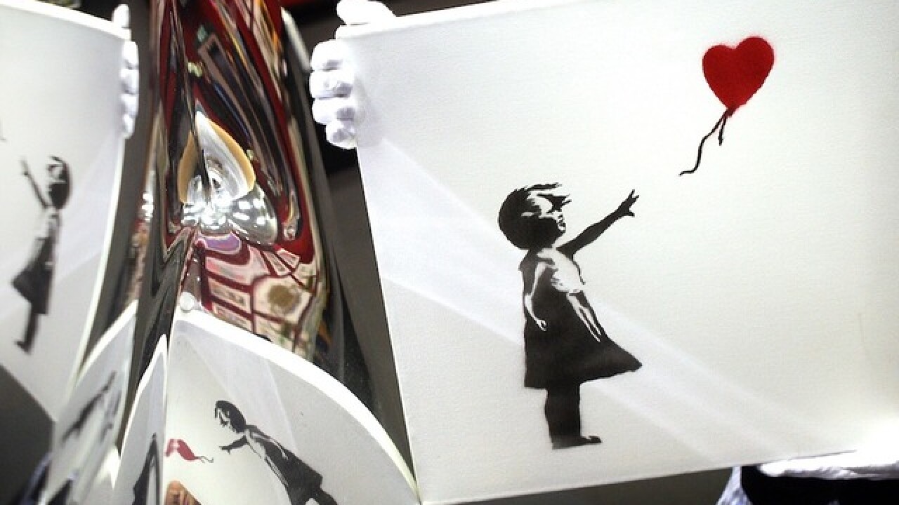 Banksy painting 'self-destructs' moments after being sold for $1.4 million at auction
