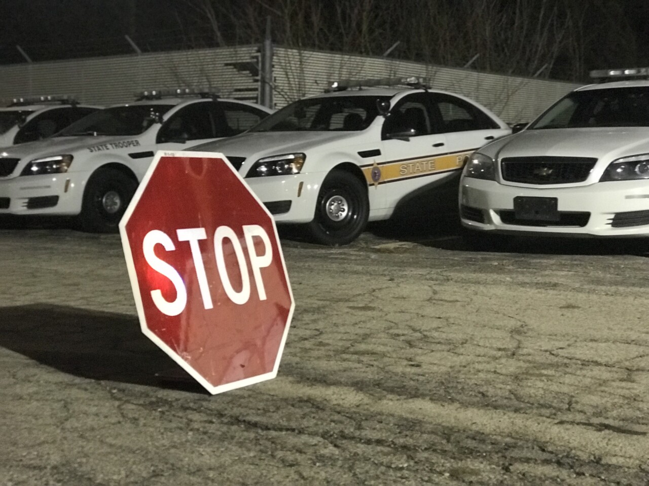 stop sign placed in front of state patrol cars at night