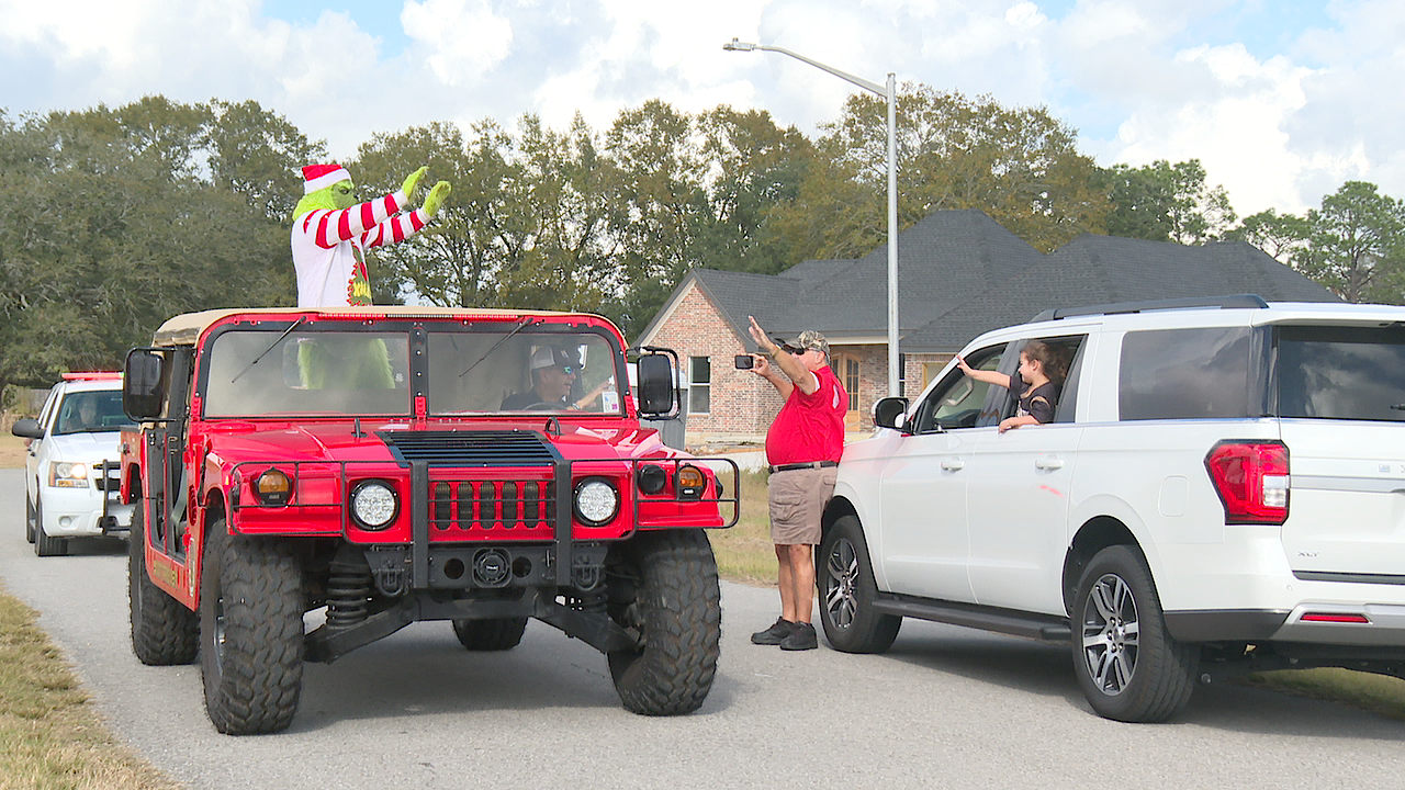 The Grinch waves to residents of Mills Terrace in Scott as he makes his way around the city.