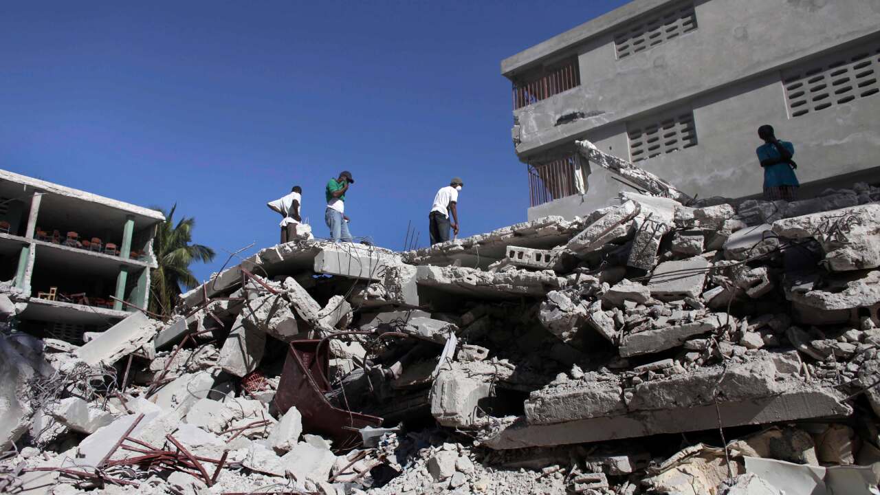 People look for survivors in the wreckage of the collapsed Catherine Flon school in Carrefour, outskirts of Port-au-Prince, Friday, Jan. 15, 2010.