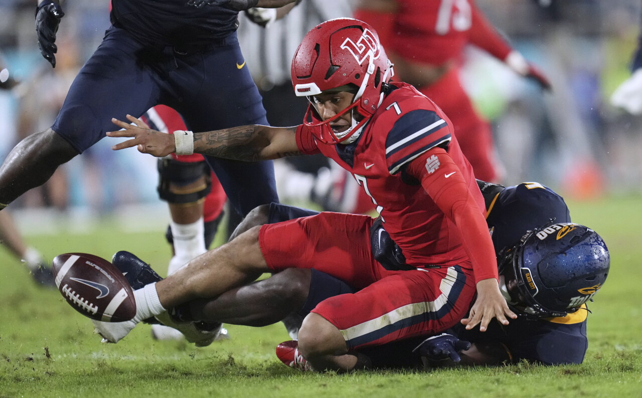 Liberty Flames QB Kaidon Salter fumbles after getting hit by Toledo Rockets deffensive end Nate Givhan during second quarter of 2022 Boca Raton Bowl