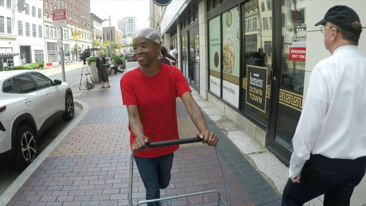 Sholonda Hall pushes her cart down Euclid Avenue after a final shopping trip to the downtown Heinen's store.