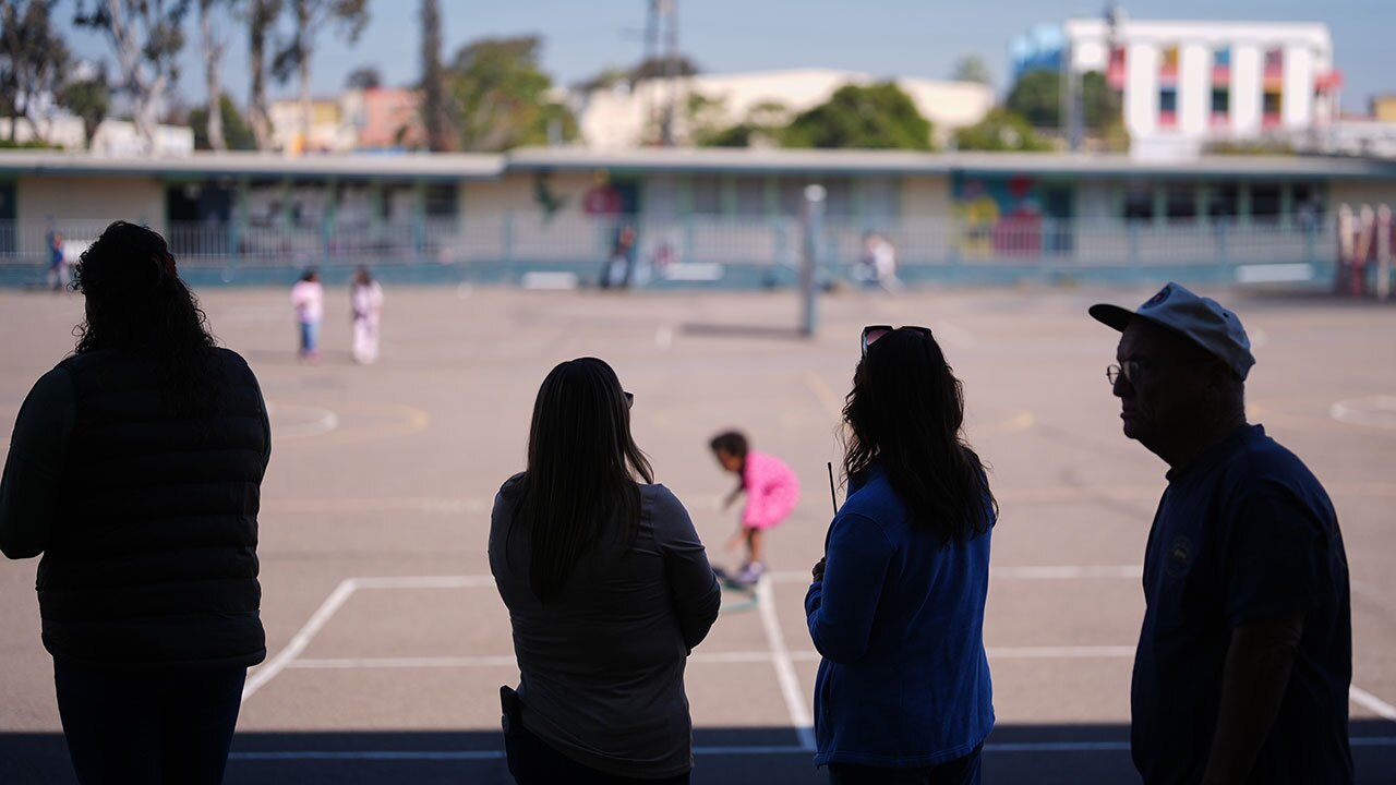 Teachers look on as students play on the playground at Perkins K-8 School Thursday, Nov. 13, 2025, in San Diego.