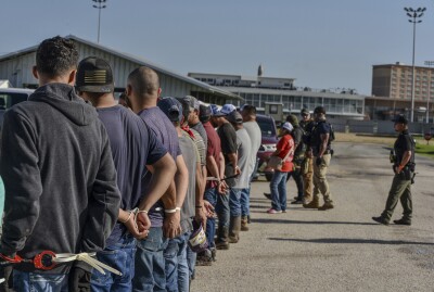 People stand handcuffed after being arrested by U.S. Immigration and Customs Enforcement.