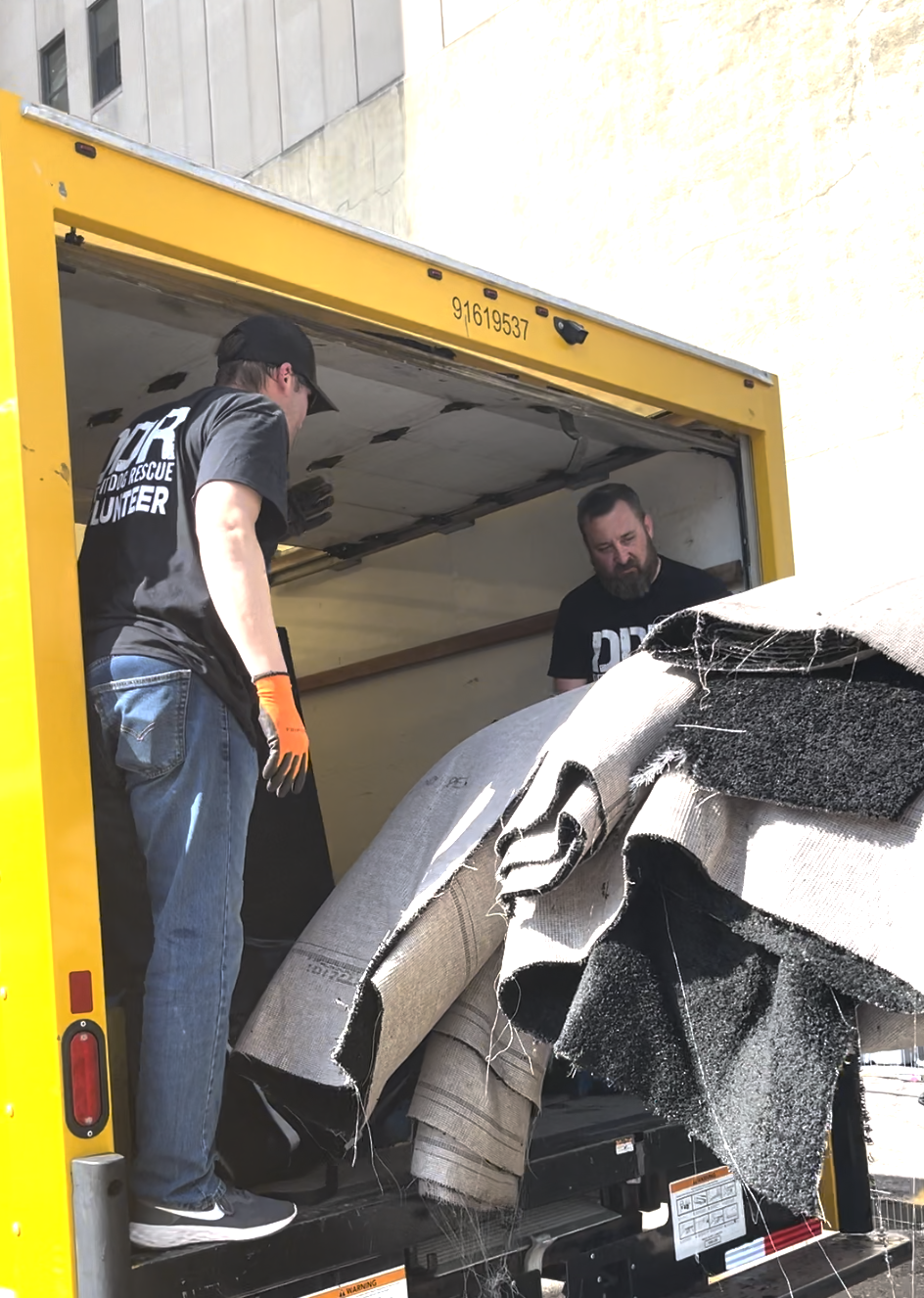 Detroit Dog Rescue staff loading up trucks of NFL Draft carpeting