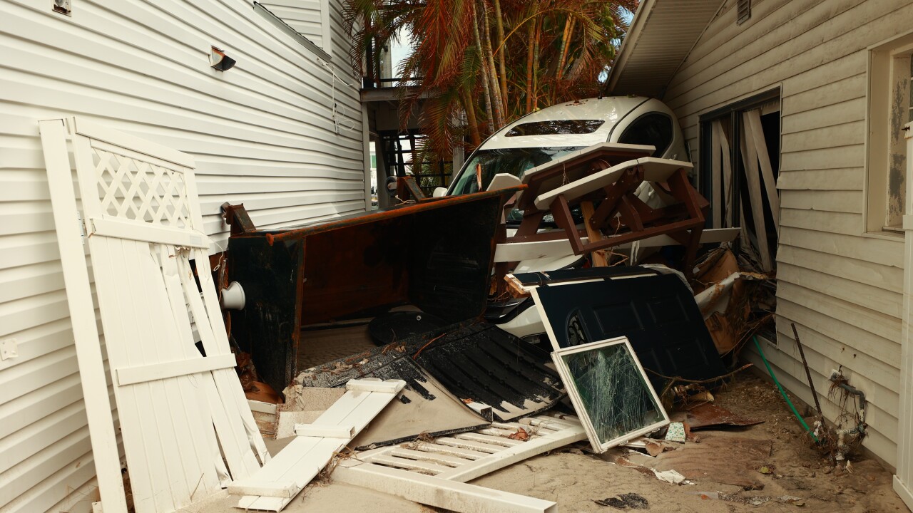A car swept between two homes during Hurricane Helene storm surge on Sunset Beach, Treasure Island Florida.