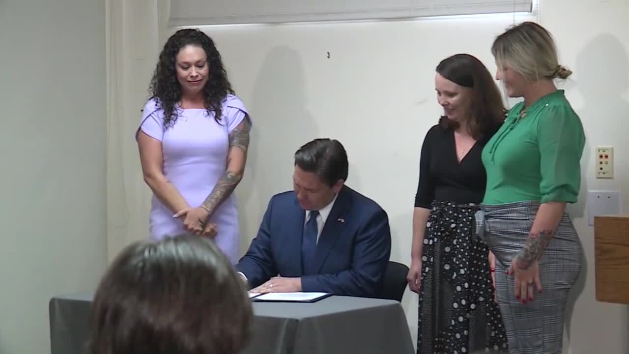 Gov. Ron DeSantis signs legislation while standing next to Jeffrey Epstein victims at Palm Beach Police Department, Feb. 29, 2024