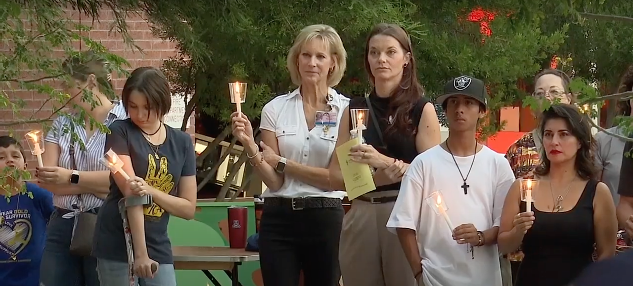 Families hold a candle in honor of a loved one with cancer