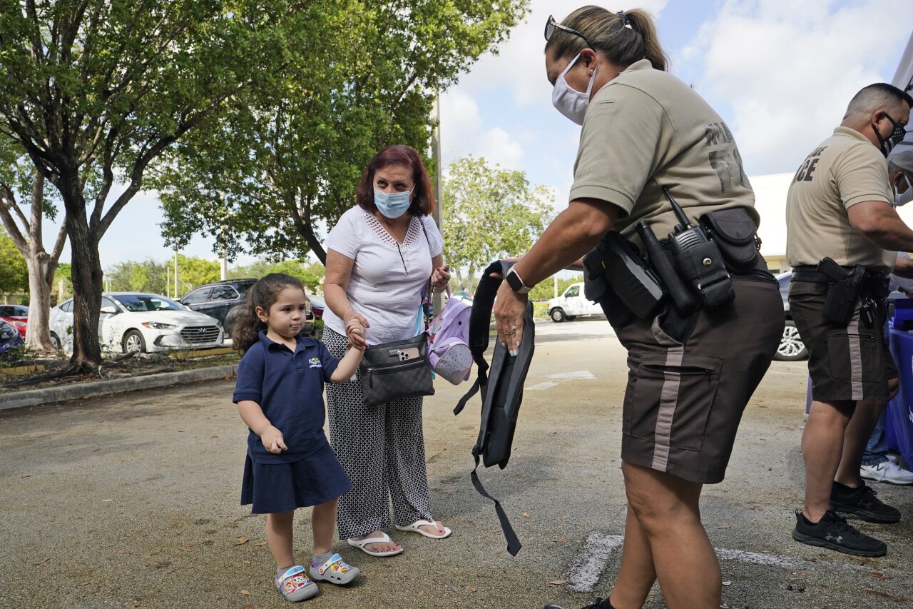 Girl receives book bag during donation drop in Miami-Dade County, July 30, 2021