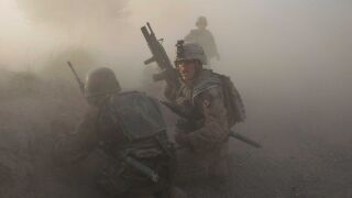 A U.S. Marine with the 2nd Marine Expeditionary Brigade, RCT 2nd Battalion 8th Marines Echo Co. along with an Afghan soldier react as dust blankets the area after an IED exploded while they were under enemy fire on July 17, 2009 in Mian Poshteh, Afghanistan.