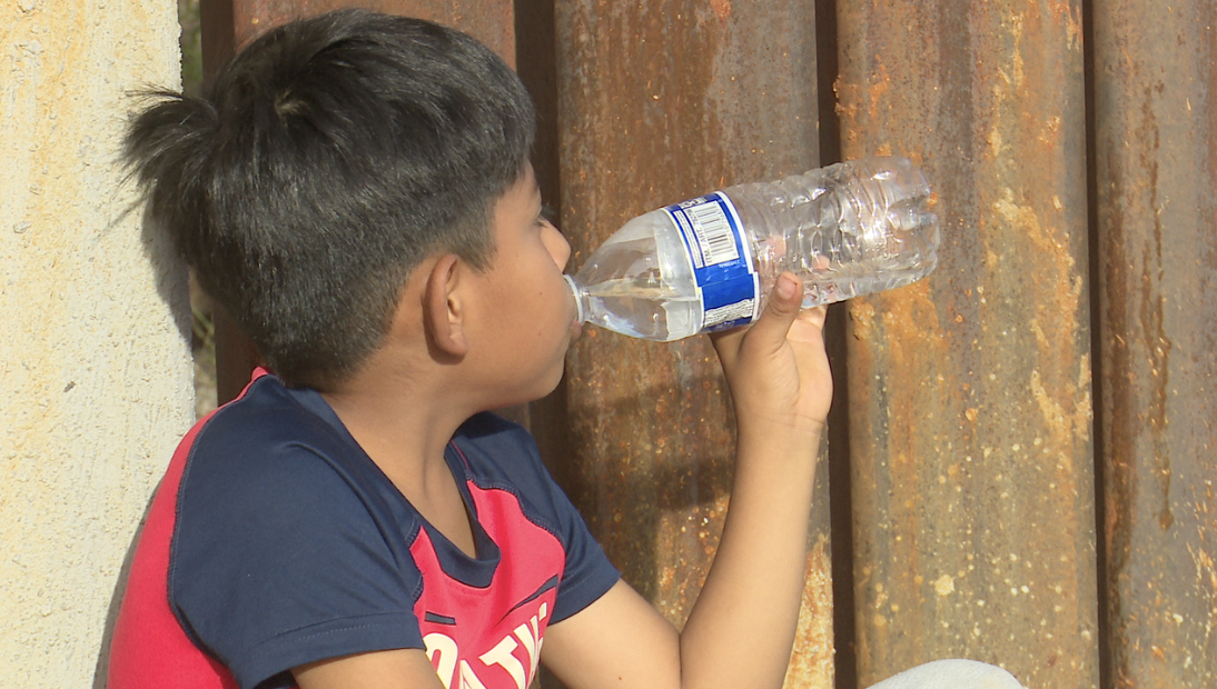 A child drinks water at the border