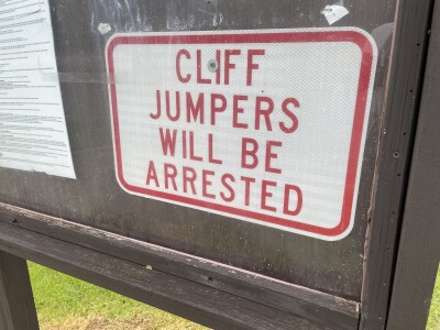 Sign that reads cliff jumpers will be arrested