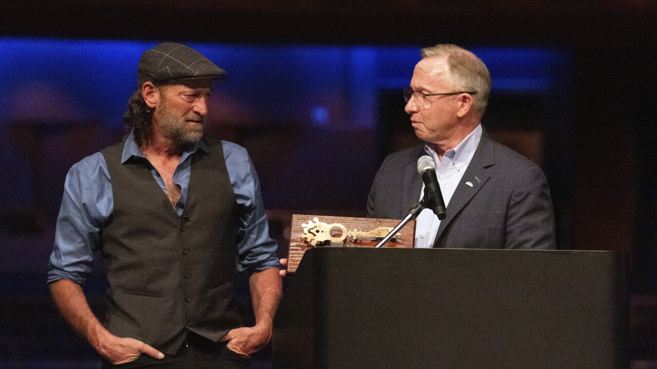 In this image provided by the City of Mesa, actor Troy Kotsur, left, receives the key to the city from Mesa Mayor John Giles, on Thursday, Aug. 11, 2022 in Mesa, Ariz. Kotsur, who made history as the first deaf man to win an Academy Award, has been honored with a key to his Arizona hometown. (Delia Johnson/City of Mesa via The AP)

