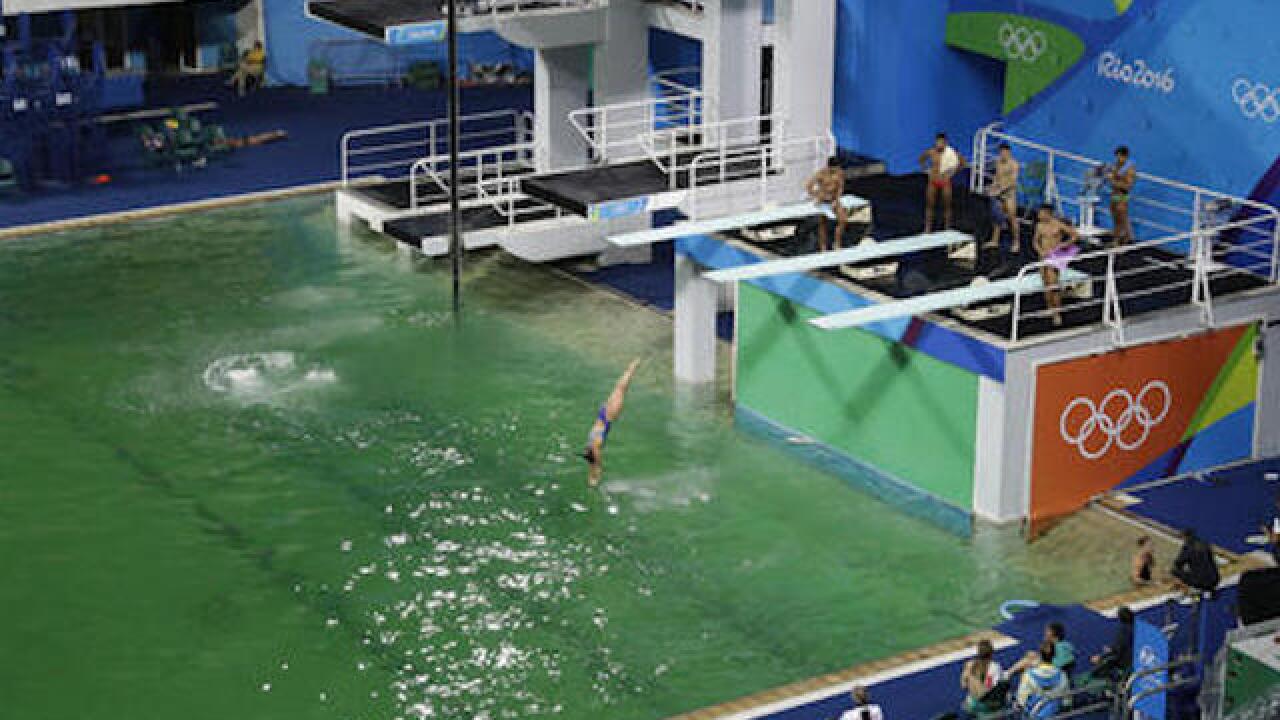 Olympic pool with green water to be drained, refilled