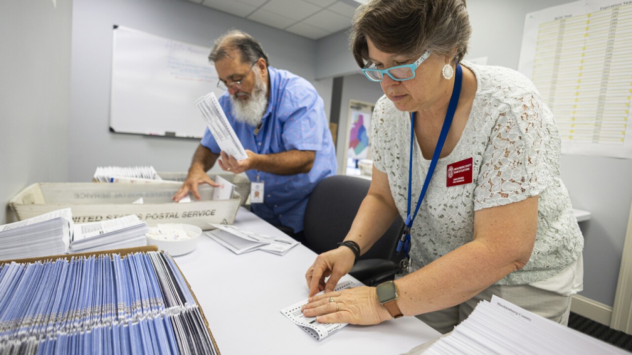 People prepare ballots to be mailed.
