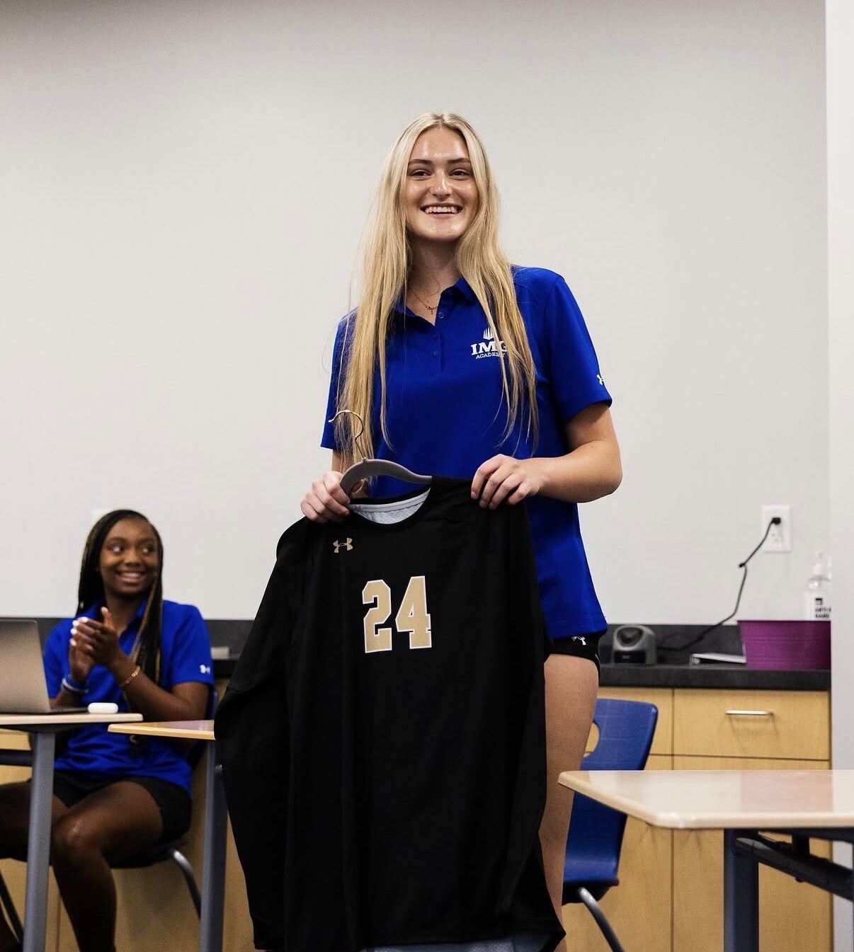 Amanda and her jersey before being hung up at IMG. CREDIT: Mack family