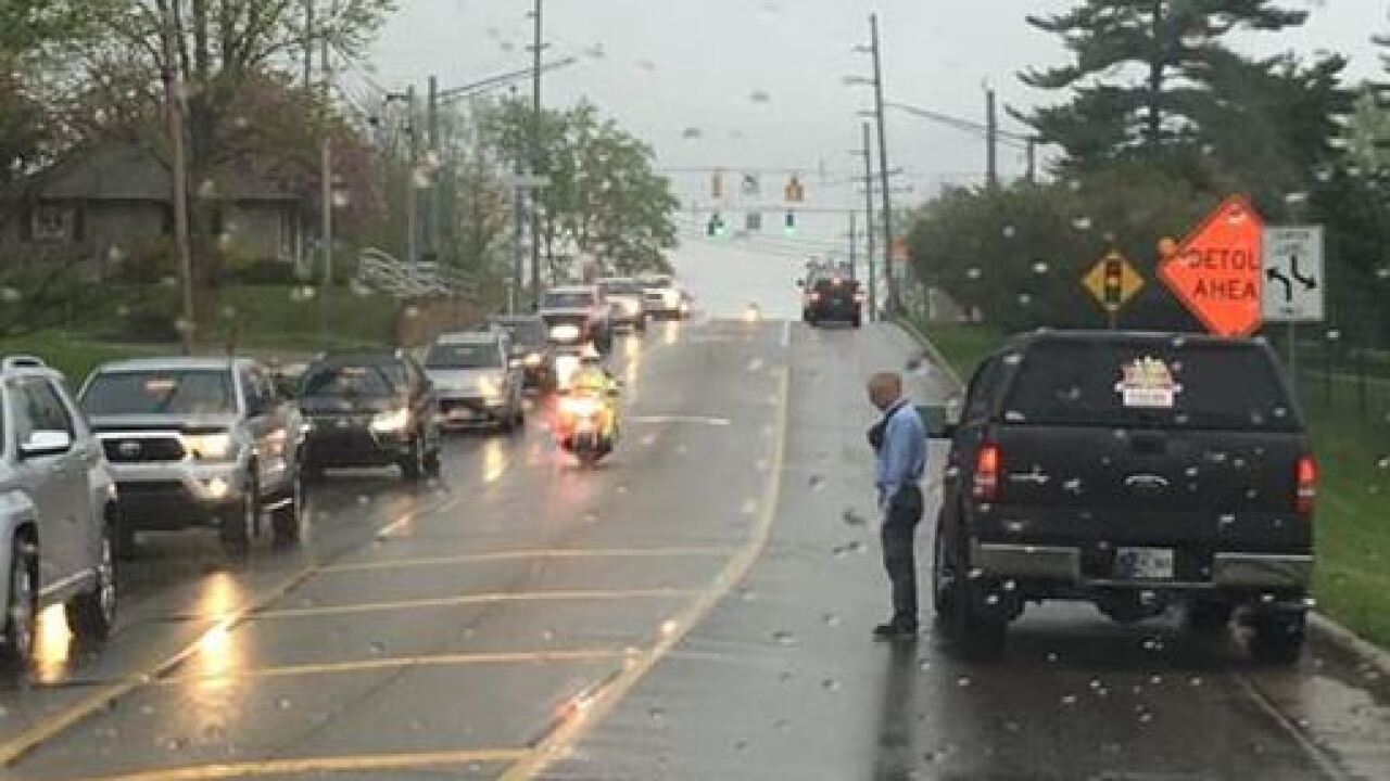 Photo of man standing at the side of the road, in the rain, during