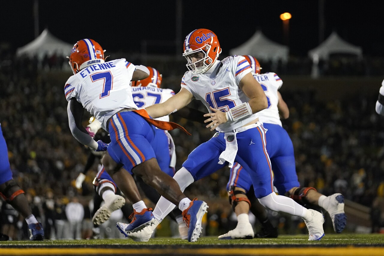 Florida Gators QB Graham Mertz hands off football to running back Trevor Etienne in first half at Missouri Tigers, Nov. 18, 2023