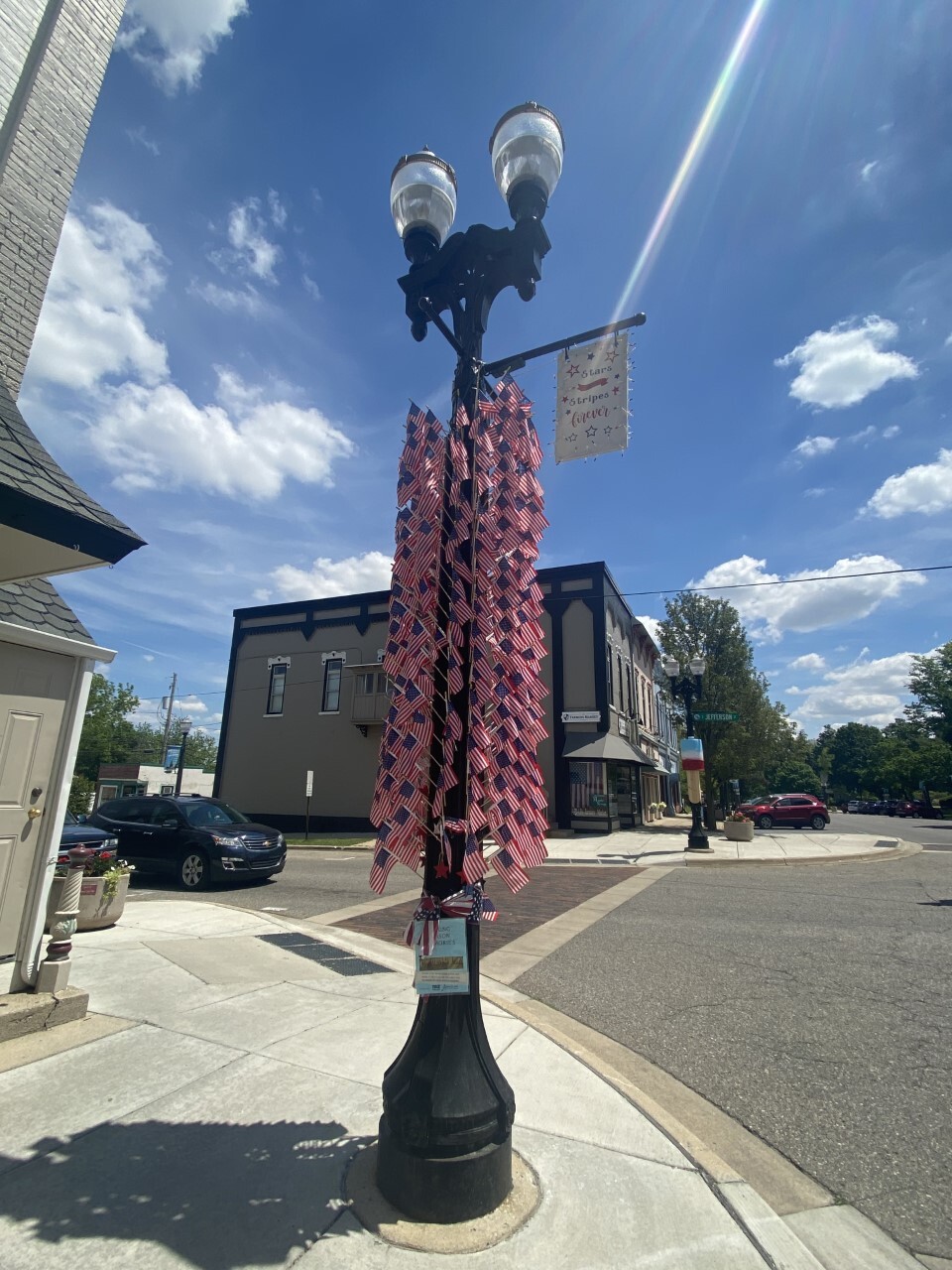 Flags in the wind light pole outside of Maple Street Mall