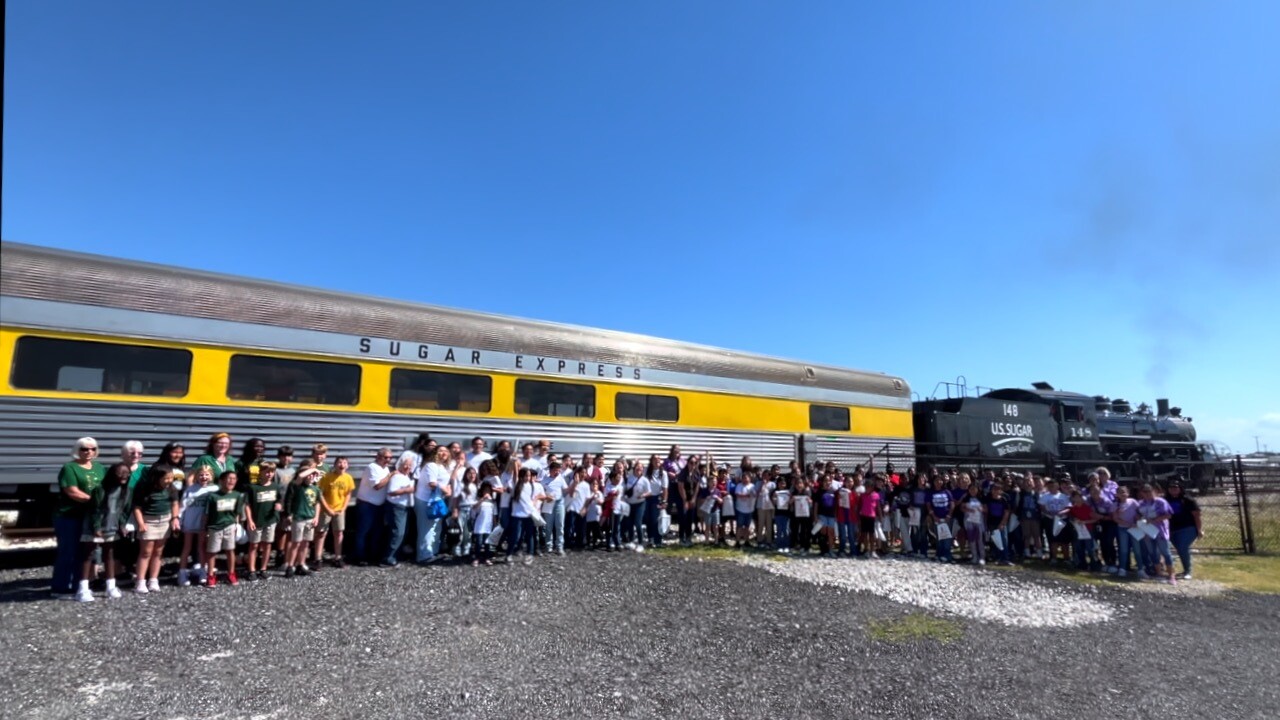 Large group of Clewiston 4th graders gather in front of the Sugar Express for a photo.